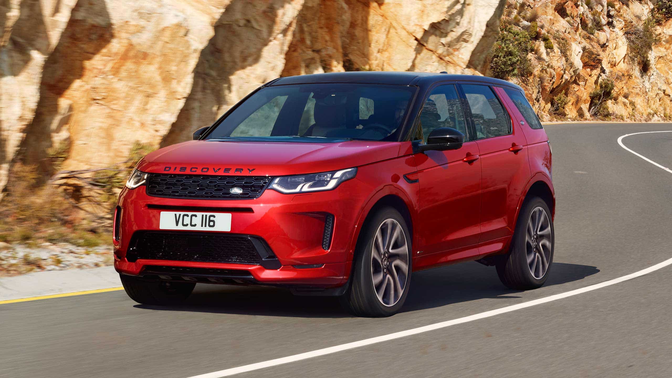 Range Rover Discovery Sport in Red driving on road
